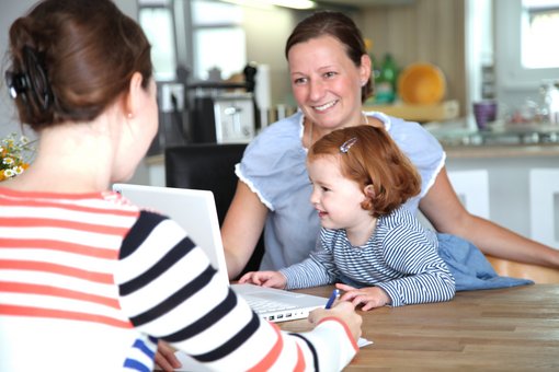 Foto von einer Mitarbeiterin des pme Familieservices, die eine junge Mutter mit Kind berät.