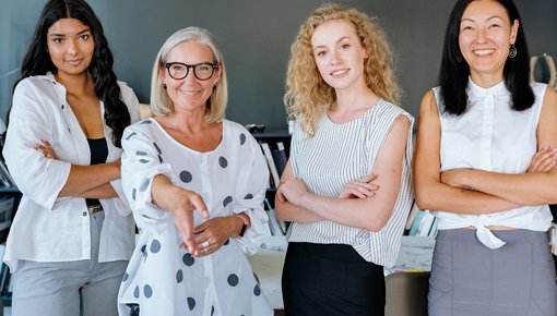 Das Foto zeigt vier Geschäftsfrauen unterschiedlichen Alters. Das Sana Frauennetzwerk EmpowerHer setzt sich für die Stärkung und Förderung von Frauen ein.