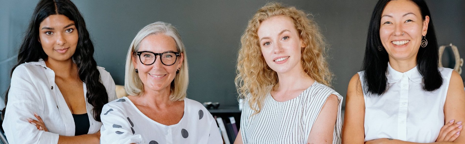 Das Foto zeigt vier Geschäftsfrauen unterschiedlichen Alters. Das Sana Frauennetzwerk EmpowerHer setzt sich für die Stärkung und Förderung von Frauen ein.